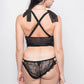 Back view of black lace corset lingerie with criss-cross straps and cheeky lace panties.