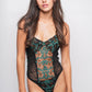 Woman wearing a  black lace lingerie bodysuit with plunging neckline and sheer floral embroidery for an elegant, sultry look.