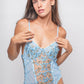 Model wearing a sheer lace lingerie bodysuit in blue, designed with floral embroidery and plunging neckline for a bold and seductive look.