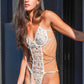 A woman models a beautiful white teddy bodysuit with floral embroidery, elegant chains, and thigh straps. Perfect for bridal lingerie and special occasions.