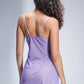 Back view of a woman in a lavender babydoll lingerie dress with sheer fabric and adjustable spaghetti straps, highlighting a flirty see-through design.