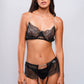 Woman wearing black lace lingerie set with garter belt, perfect for bedroom wear and romantic nights