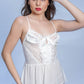 Woman in white lace babydoll dress with satin bow, perfect for bridal lingerie or honeymoon nightwear.