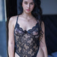 Model in sheer black lace teddy bodysuit with bow accent at the front.