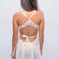 Back view of white lace babydoll lingerie tied with satin ribbon, bridal bedroom wear.