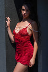 Model posing outdoors in sheer red babydoll lingerie with lace and pearls, ideal for special nights in.