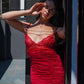 Woman in red lace babydoll with pearl accents posing in sunlight, intimate lingerie for special occasions.