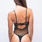 Rear view of black fishnet teddy bodysuit with thong back — daring roleplay lingerie for couples.