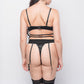 Rear view of a woman wearing a black satin lingerie set with a thong and garters. This boudoir set is ideal for special occasions and intimate evenings.