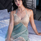 Model sitting on bed in green lace babydoll nightwear, perfect for romantic date nights at home.