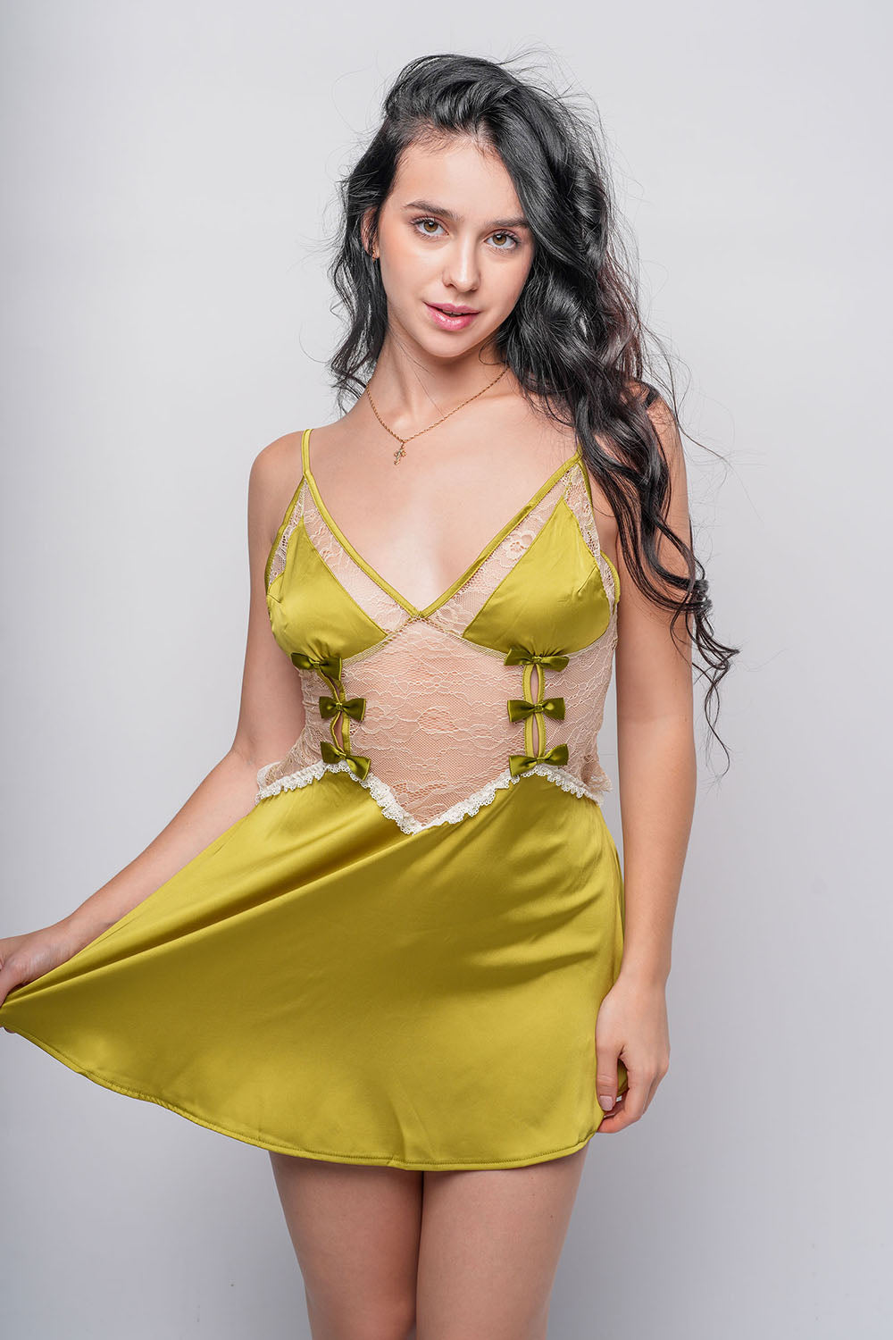 Green satin babydoll dress with lace detailing and bow accents, playful bedroom wear.