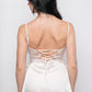 Back view of white satin babydoll dress with lace-up ribbon detail and lace hem.