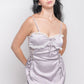 Woman in light purple satin babydoll dress with lace trim and ribbon bows, front view.