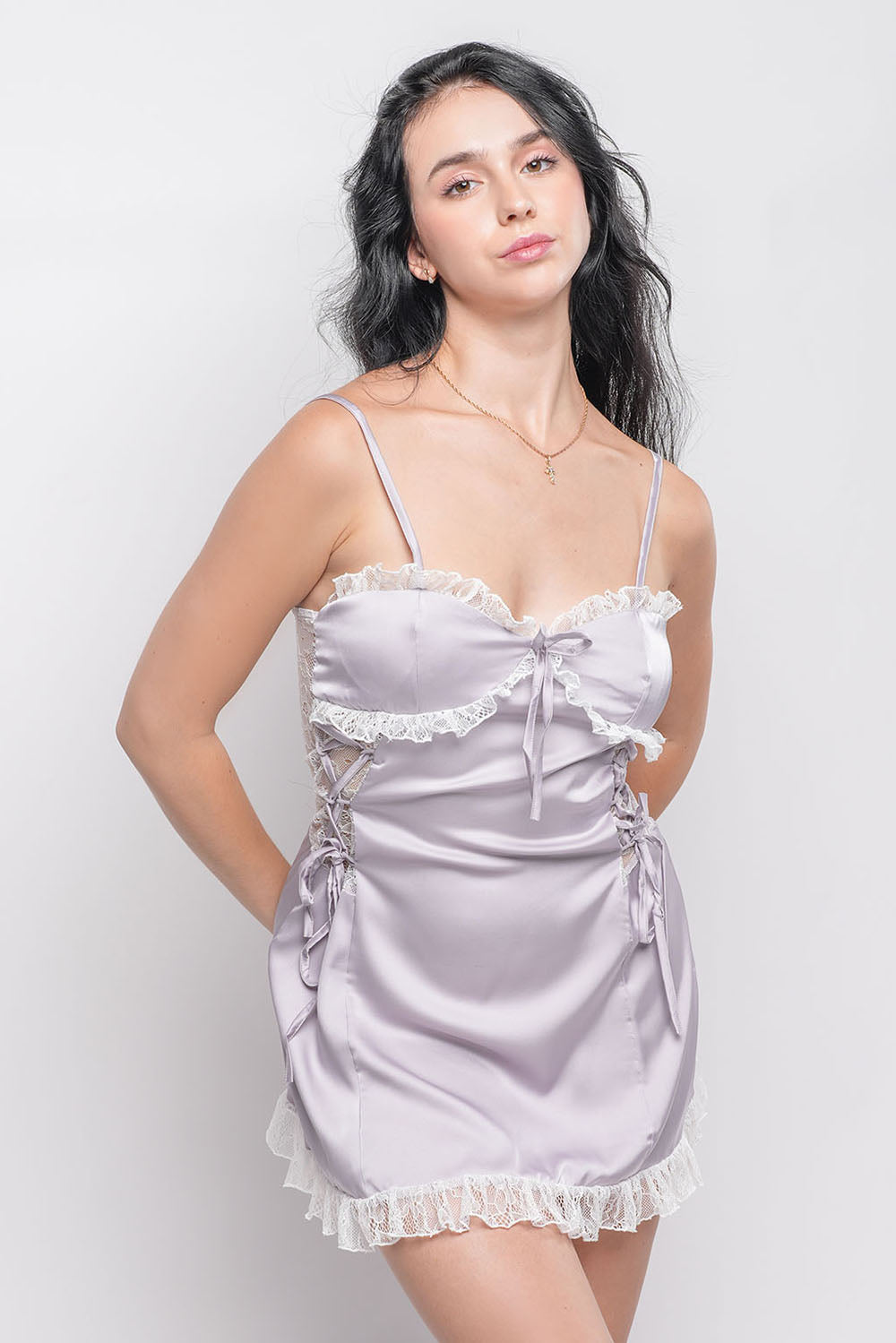 Woman in light purple satin babydoll dress with lace trim and ribbon bows, front view.