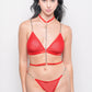 Model in red lingerie set with chain harness, bold bedroom wear for date night.