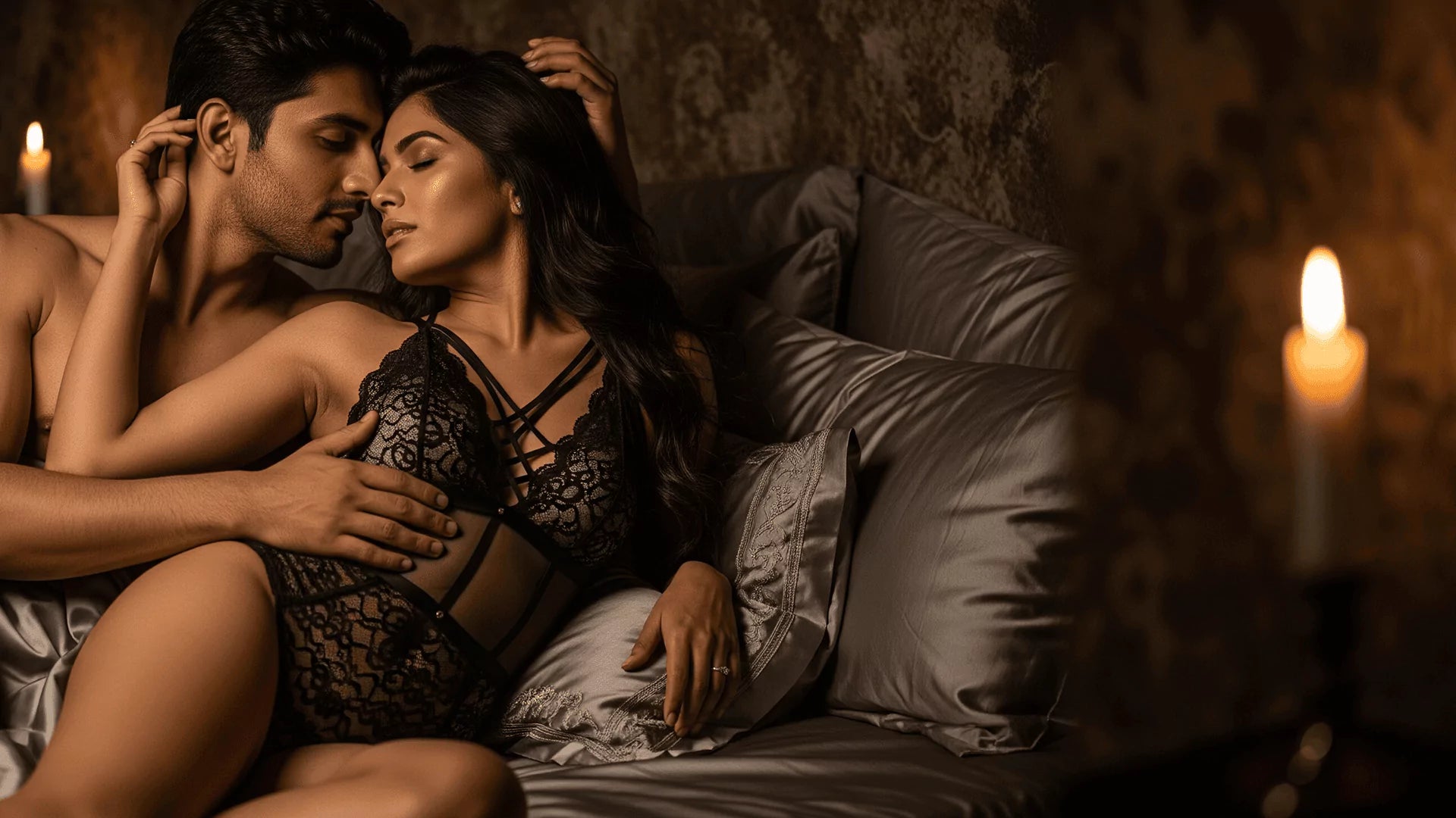 Couple in honeymoon lace lingerie dress embracing on a bed with candles in the background